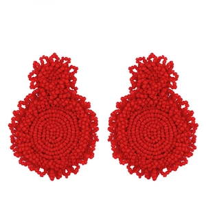 Detail of red handmade beaded earrings featuring a double circular drop design