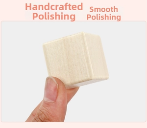 Close-up of hand holding a hand-polished natural wood cube with smooth rounded edges