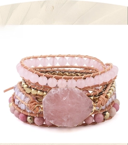 Detail of bohemian wrap bracelet with rose quartz, gold beads and brown leather cord