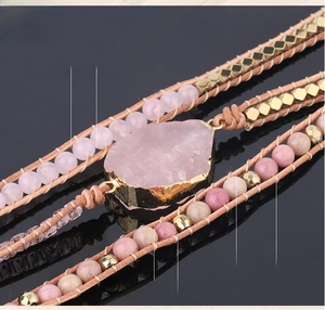 Macro shot of rose quartz beaded bracelet with gold-plated stone and woven details