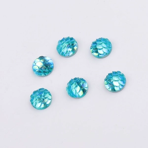 Macro detail of 8mm blue fish scale resin flatback cabochons with AB rainbow finish