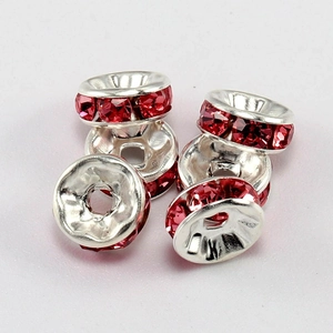 Detailed view of silver rondelle spacer beads with red rhinestones for DIY jewelry
