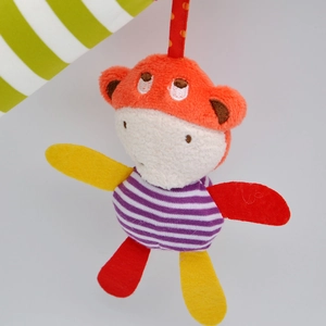 Close-up of a colorful plush monkey toy with purple stripes and soft fabric texture