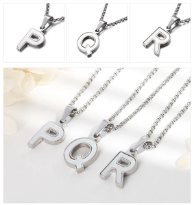 Vue macro des pendentifs lettres P, Q, R en argent avec émail blanc sur chaîne