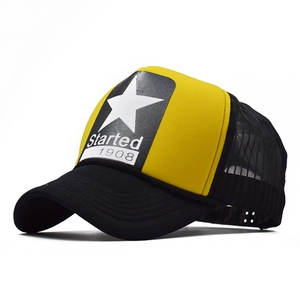 Detail of yellow trucker hat featuring a white star print and black mesh back panels