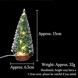 Close-up of a 15cm mini LED Christmas tree with snow flocking and a rustic wood base