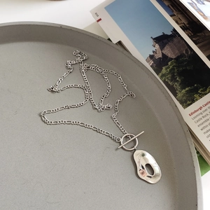Detailed view of 925 sterling silver necklace with irregular hollow oval pendant and OT clasp