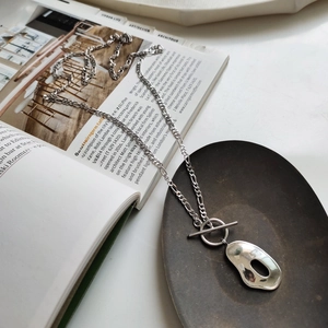 Silver 925 irregular hollow oval pendant necklace with OT toggle clasp on a magazine