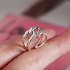 Close-up of a polished S925 sterling silver ring with a bold chain link woven design