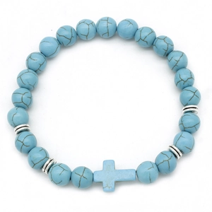 Detail of blue turquoise style beads with a cross charm on an elastic bracelet