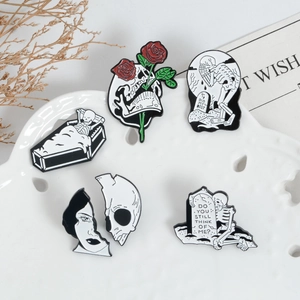 Gothic punk enamel brooches featuring skull coffin and gravestones on a ceramic tray