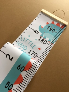 Detail of canvas height chart with blue cartoon dinosaur and wooden hanging scroll