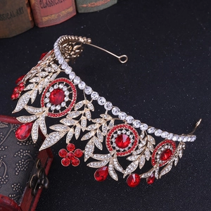 Close-up of golden bridal crown with red rhinestones on a vintage jewelry box