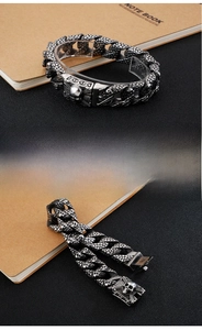 Detail of vintage punk titanium steel skull bracelet with intricate textured link chains