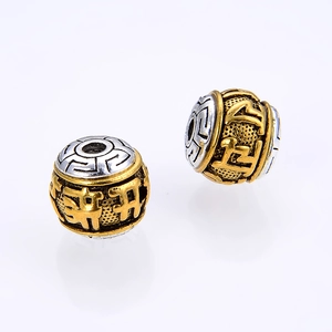 Close-up of two-tone alloy Buddhist beads with engraved Six-Word Mantra for DIY jewelry