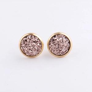 Macro detail of 10mm gold plated stud earrings with sparkling pink mineral crystals