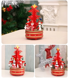 Detailed view of red wooden Christmas tree music box with miniature figurines