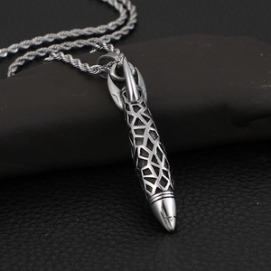 Vintage stainless steel rocket pendant necklace with mesh texture on stone background