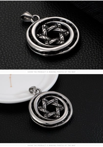 Detailed macro view of a silver hexagram pendant on black textured leather surface