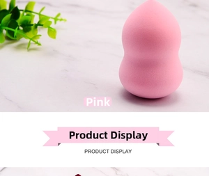Pink teardrop beauty sponge for makeup application on a modern marble countertop