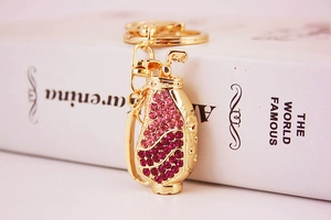 Macro shot of gold golf bag keychain with pink rhinestones leaning on a book