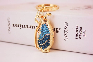 Macro shot of golden golf bag keychain with blue crystals and number 34 engraving