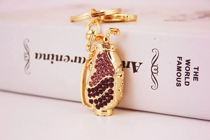 Close-up of golden golf bag keychain with sparkling purple and red rhinestones on book
