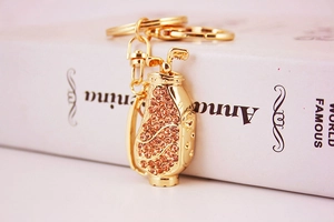 Detailed view of a golden golf bag keychain encrusted with sparkling champagne rhinestones