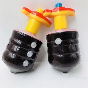 Close-up of two colorful spinning tops with black bodies and red-yellow handles
