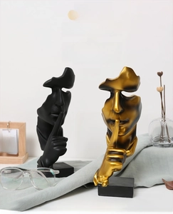 Detailed view of creative Silence is Gold resin sculptures in matte black and gold finish