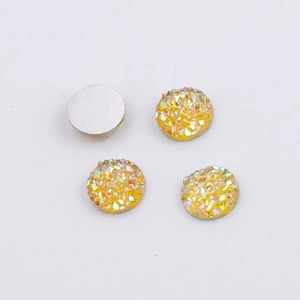 Macro detail of 8mm yellow faceted resin rhinestones showing flat silver backing