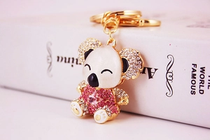 Detailed view of koala keychain with white opal and pink rhinestones on gold metal