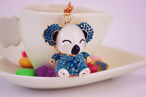 Detail of koala keychain with blue rhinestones and star gemstone on gold metal