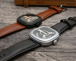 Close-up of square dial quartz watches with unique rotating discs and leather straps