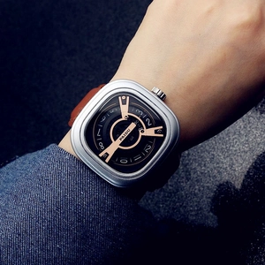 Punk style square dial watch with silver case and brown leather strap on male wrist