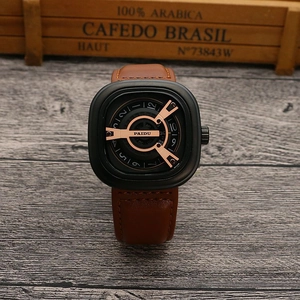 Detail view of square black punk watch with brown leather strap on dark wood