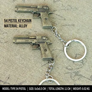Detailed close-up of two alloy pistol-shaped keychains on rustic burlap background