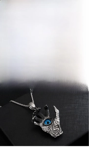 Macro detail of gothic claw pendant with blue eye stone and silver twist chain