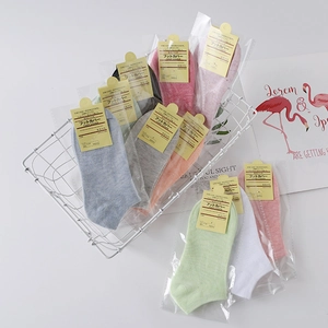 Multi-color cotton low cut foot cover socks in a decorative white metal basket