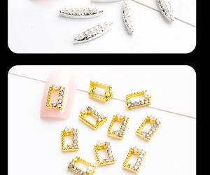 Macro view of alloy nail charms with pearls and rhinestones on polished silver and gold bases