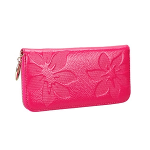 Close-up of rose red leather wallet featuring pebble texture and embossed floral accents