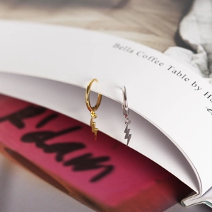 Dettaglio di orecchini a cerchio minimalisti in argento 925 con fulmini oro e argento