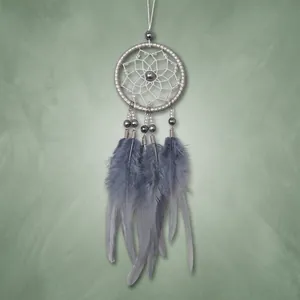 Macro detail of fluffy grey feathers and beads hanging from a dreamcatcher