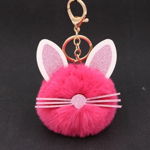 Cute pink plush kitten head keychain with glittery ears and golden metal clasp on black background