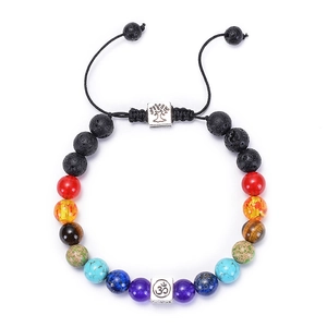 Detail of 7 chakra lava stone bracelet with Tree of Life and Om charms on black wax cord