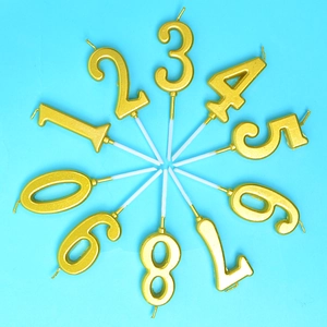 Golden 0-9 number birthday candle set with metallic finish on light blue background