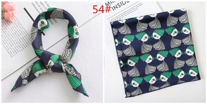 Detail of navy blue satin neckerchief featuring green artistic face pattern prints