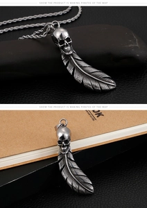 Macro shot of retro stainless steel skull and feather pendant with antique silver finish