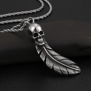 Vintage stainless steel skull and feather pendant necklace with a distressed silver finish
