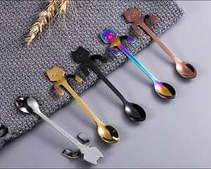Detail view of five multi-colored 304 stainless steel cat-shaped dessert and coffee spoons